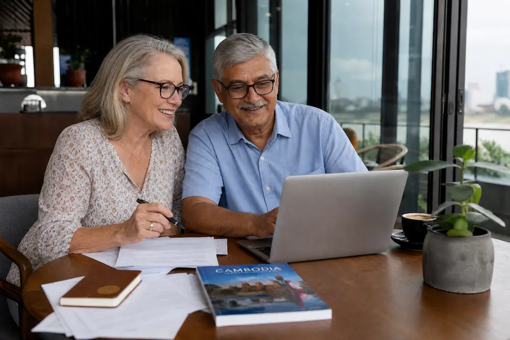 Retired couple planning Cambodia visa in cafe