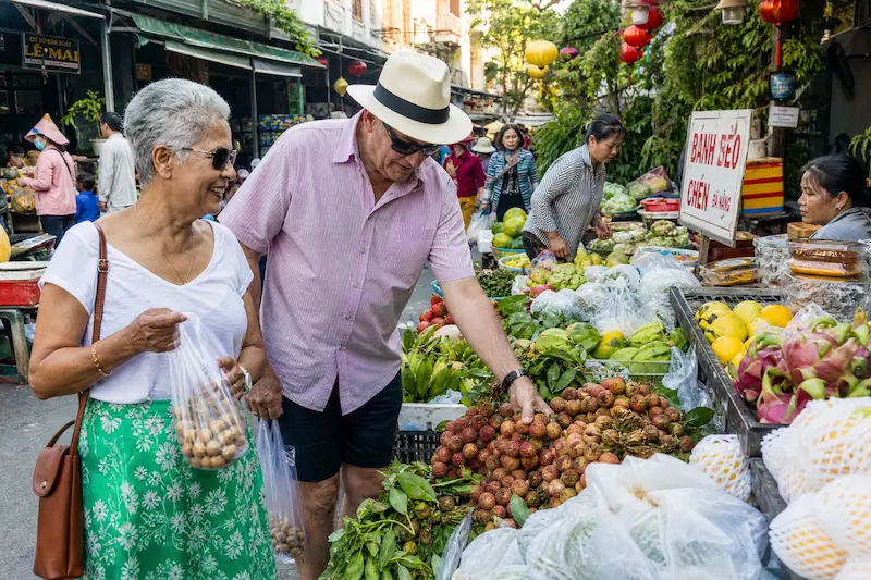 Australian retired couple shopping at Hoi An market Vietnam