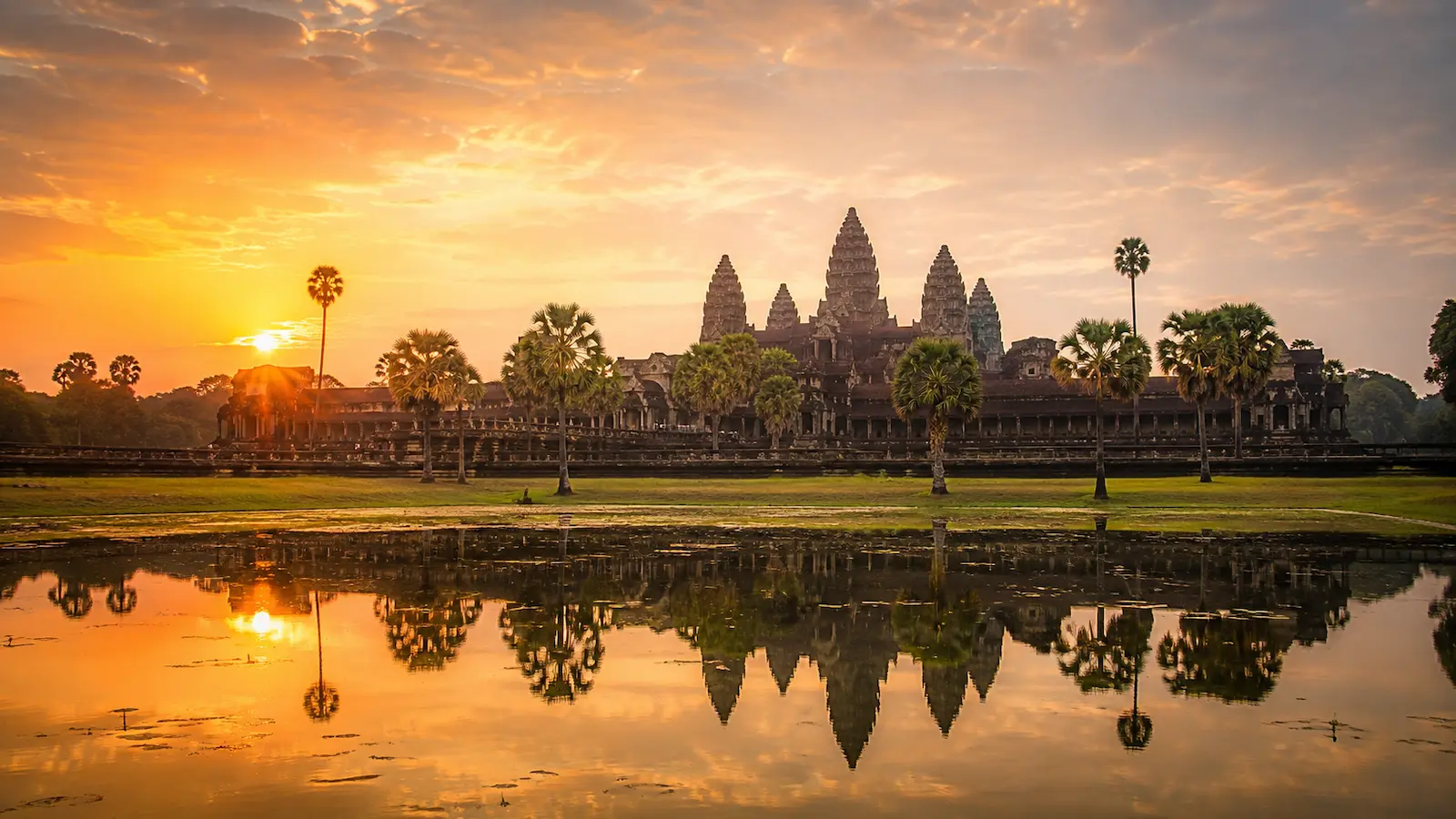 Wide view across the reflecting pools in Cambodia, warm early-morning light